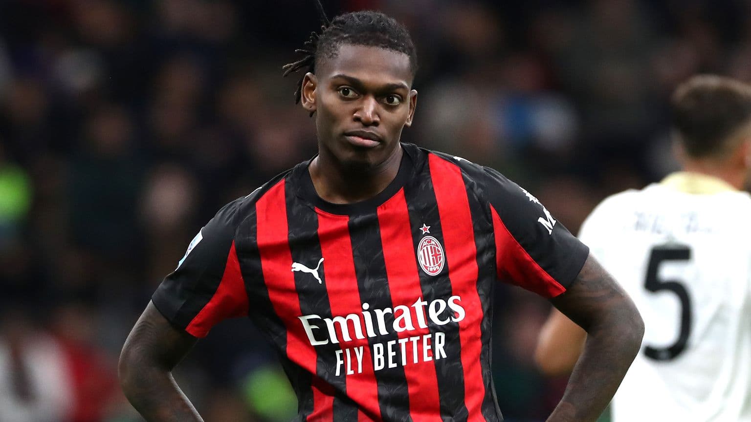 Игрок AC Milan в черно-красной форме на поле