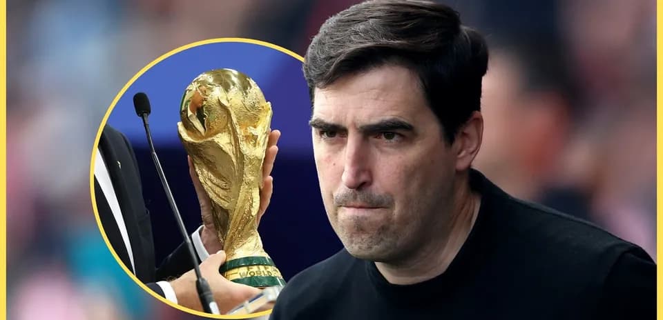 Тренер с серьезным выражением лица рядом с кубком