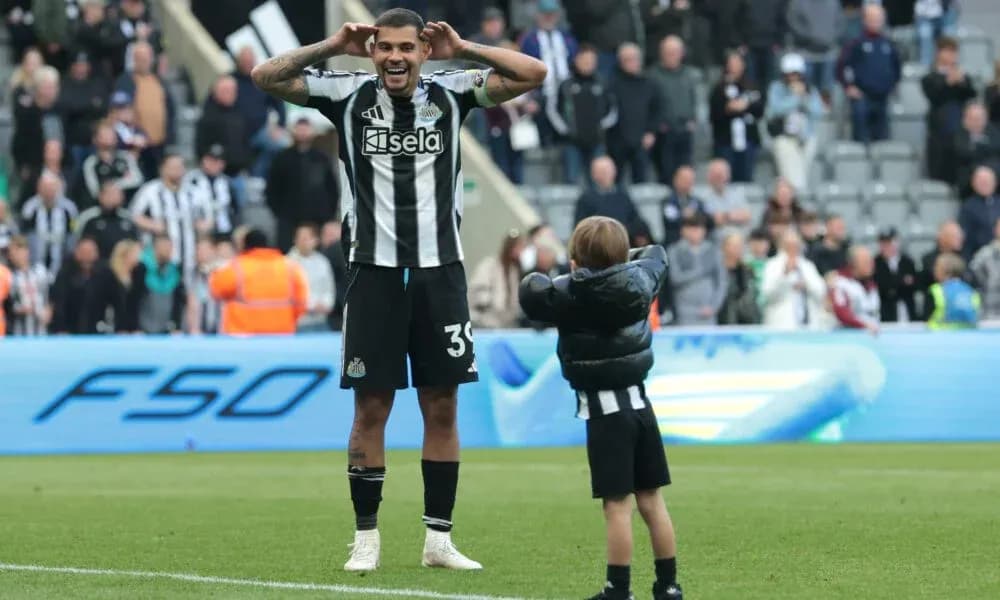 Игрок Newcastle United взаимодействует с ребенком на поле Игрок Newcastle United взаимодействует с ребенком на поле