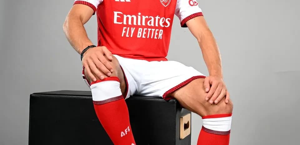 Игрок в красной форме Arsenal с мячом
