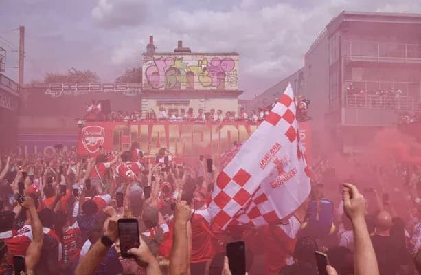 Фанаты Arsenal празднуют победу с дымом и флагами