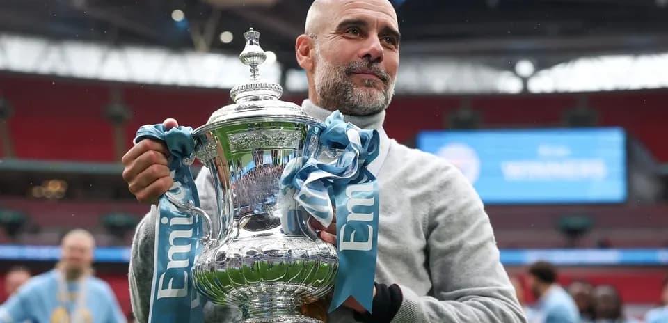 Тренер держит трофей на стадионе Wembley