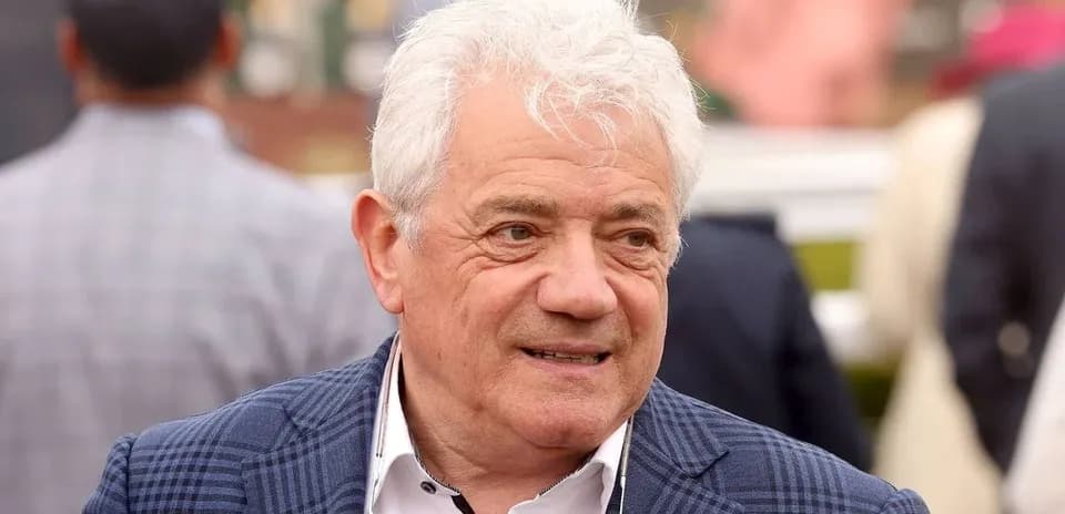 Человек в костюме на фоне толпы зрителей