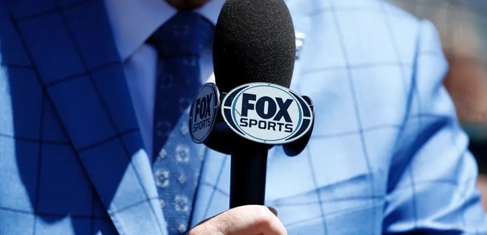 Микрофон FOX Sports в руках человека в костюме