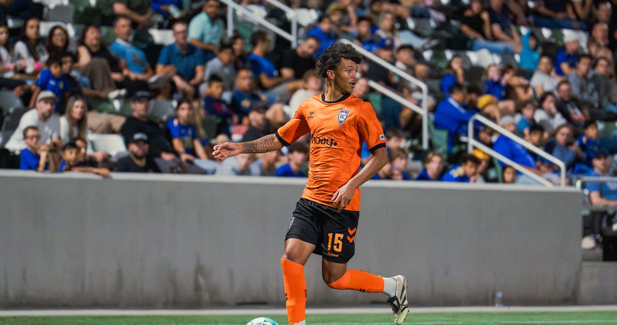 Игрок Orange County SC с мячом на поле Игрок Orange County SC с мячом на поле