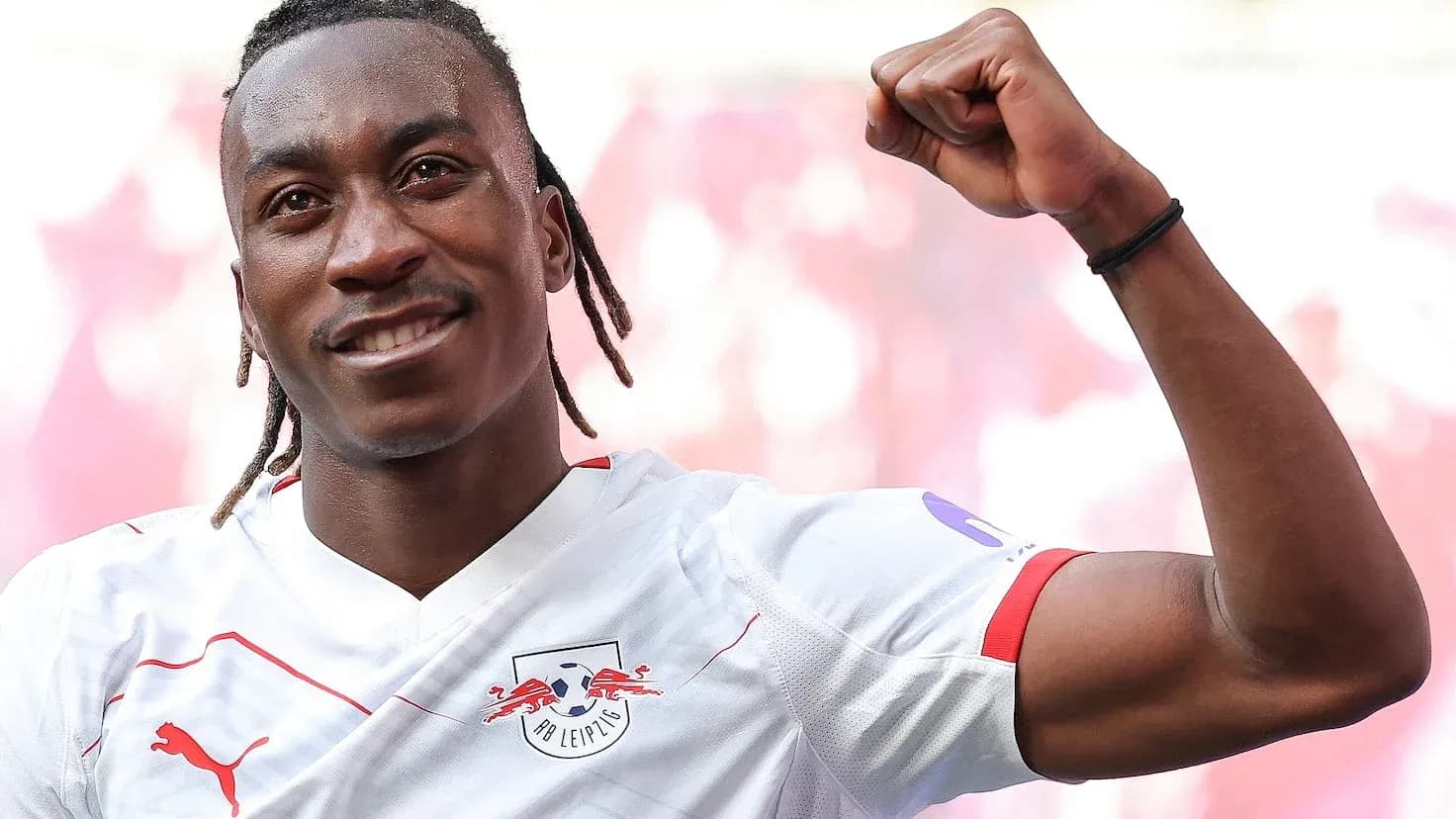 Игрок RB Leipzig празднует успех с поднятым кулаком Игрок RB Leipzig празднует успех с поднятым кулаком